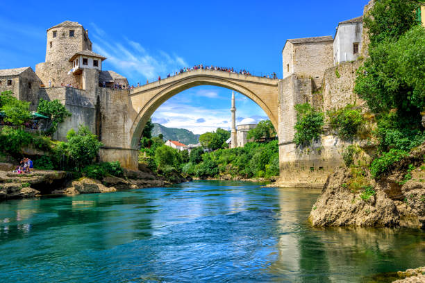 Old Bridge and Mosque in the Old Town of Mostar, Bosnia Historical Stari Most (Old Bridge) and Koski Mehmed Mosque in the Old Town Mostar on Neretva River, Bosnia and Hercegovina stari most mostar stock pictures, royalty-free photos & images