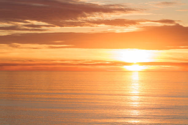 istock Bright golden dramatic sunset sun reflecting orange, gold, off calm ocean 1031139392