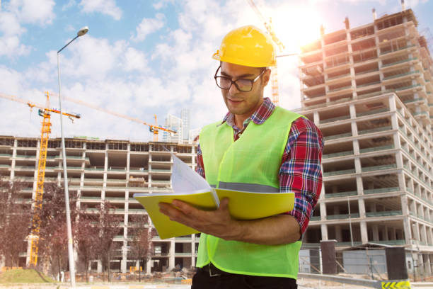 istock Young Engineer portrait with construction site and crane background. 1031144192