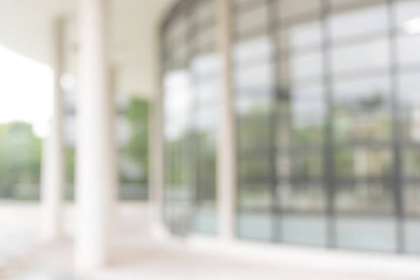 istock Office or university building blur background exterior view with blurry empty lobby space, entrance hall glass wall window and light bokeh 1031169748