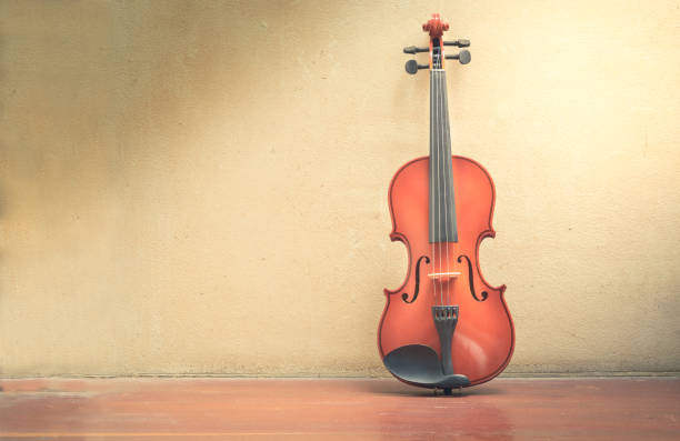 istock Wooden violin with old wall and wood floor. 1031170052