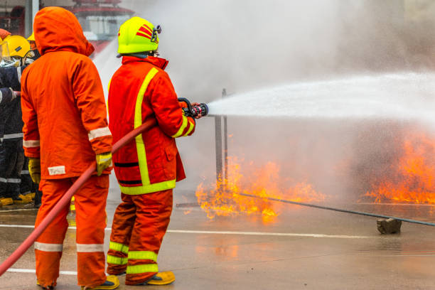 istock Firefighters training , Firefighter spraying high pressure water to fire 1031177734