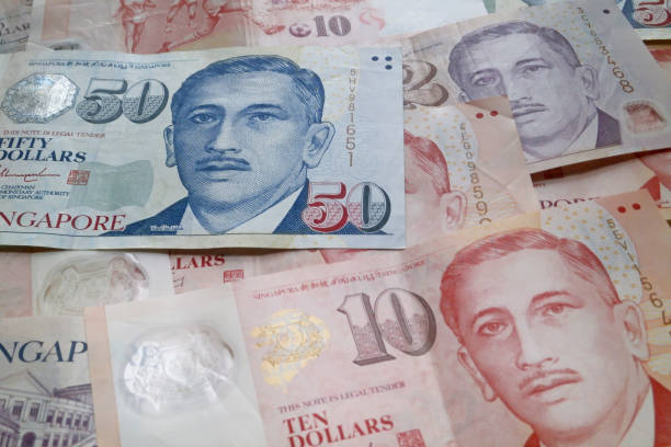 Stack of Singaporean dollar banknotes Stack of Singaporean dollar banknotes as background. singapore cash stock pictures, royalty-free photos & images
