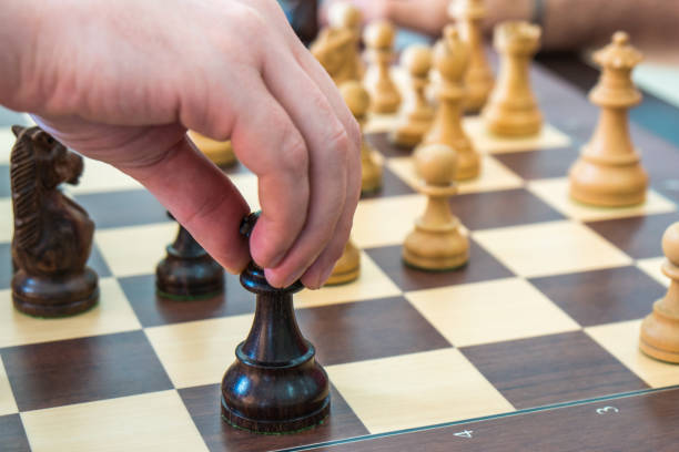 istock Hand moving a wooden chess figure on a chess board 1031245858
