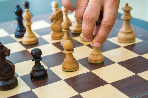istock Hand moving a wooden chess figure on a chess board 1031245870