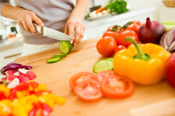 istock Closeup on young woman slicing vegetables 1031248524