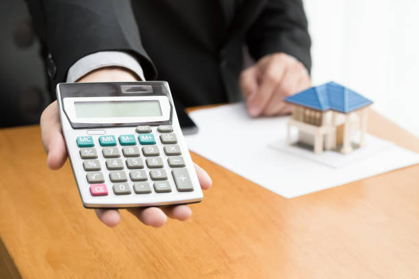 istock Man counting payments for home, mortgage concept 1031258380