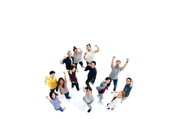 Group of Diversity People Team looking at camera with isolated white floor background. Creative teamwork feeling happy, enjoy and engage with achievement project with overhead aerial view concept. Group of Diversity People Team looking at camera with isolated white floor background. Creative teamwork feeling happy, enjoy and engage with achievement project with overhead aerial view concept. cheering group of people success looking at camera stock pictures, royalty-free photos & images