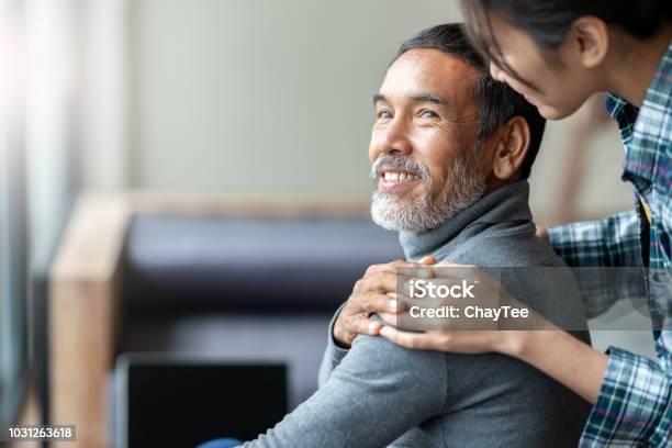 Smiling Happy Older Asian Father With Stylish Short Beard Touching Daughters Hand On Shoulder Looking And Talking Together With Love And Care Family Relationship With Bond And Care Concept Stock Photo - Download Image Now