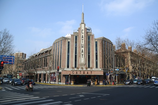 People on the street at the historical art deco Cathay Cinema, built in 1931 along Huaihai road, Shanghai, China.