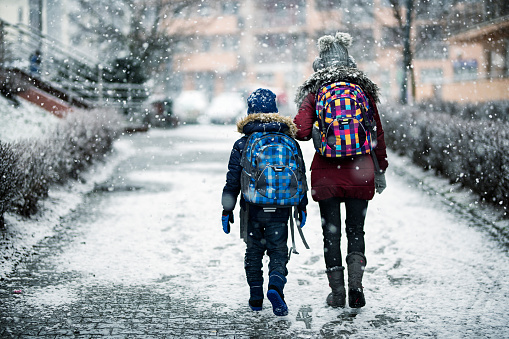 Brother and sister going to school on winter day. Elder sister aged 12 is walking her younger brother aged 8 to school.
Nikon D850