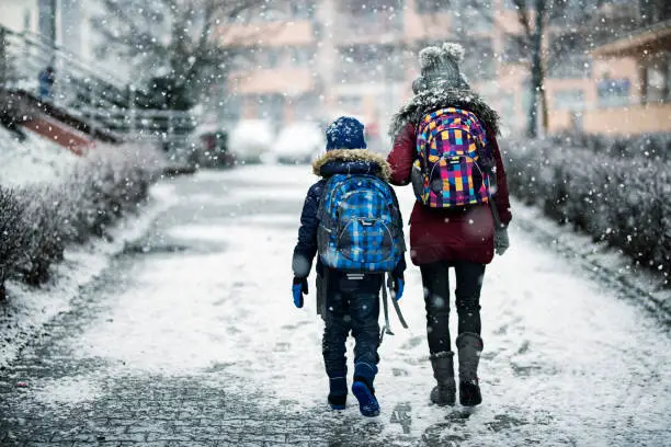 Photo of Brother and sister going to school on winter day