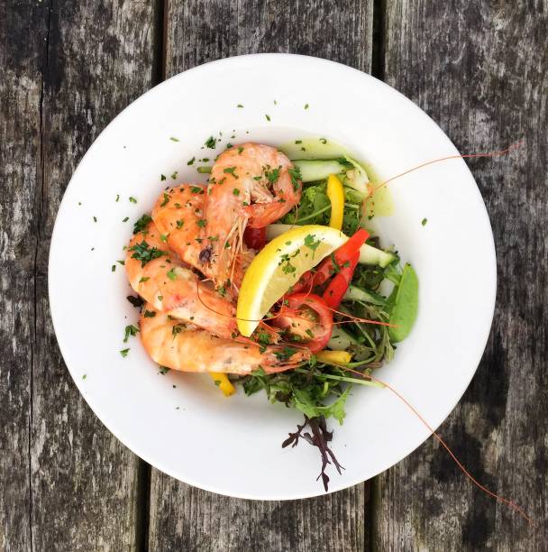 A prawn seafood platter Looking down from above onto a plate with a prawn seafood dish with salad and fresh prawns seafood salad stock pictures, royalty-free photos & images