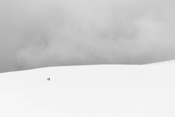 istock A very minimalistic view of two distant people over a mountain covered by snow 1031281574