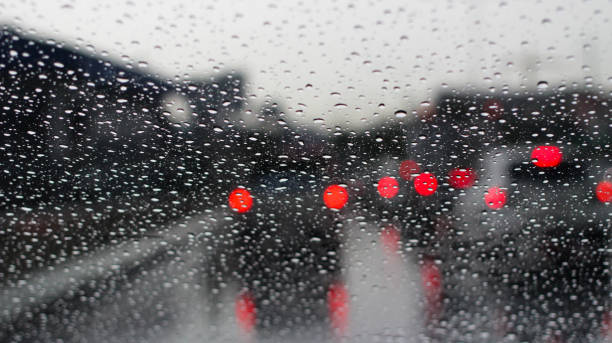 istock drop water raining and red bokeh traffic jam on rode way, background concept. 1031281748