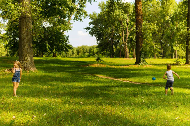 istock Small kids playing with ball in nature. 1031291430