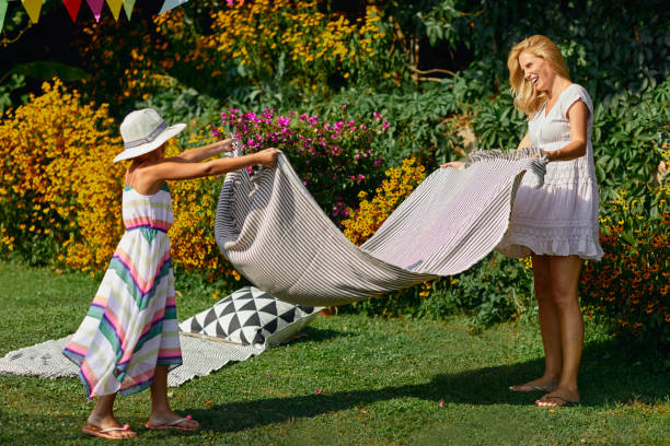 istock Mother and daughter spreading picnic blanket 1031291904