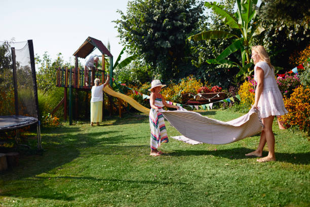 istock Mother and daughter spreading picnic blanket 1031292152