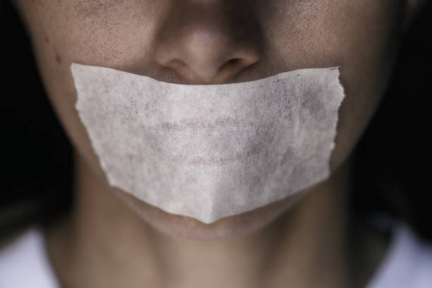 Censorship in the Modern World: A man's mouth sealed with an adhesive tape, close-up stock photo