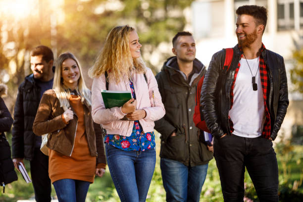 istock Group of college students walking on university campus 1031303080