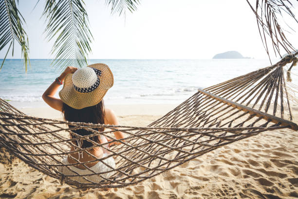 istock Happy woman relaxing in hammock 1031303594
