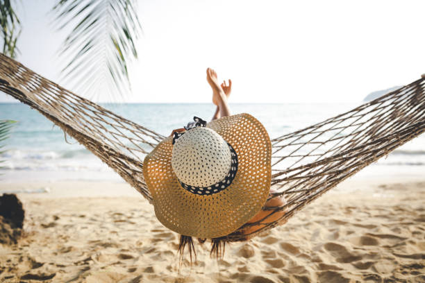 istock Happy woman relaxing in hammock 1031303606