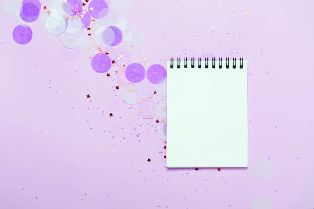 istock Empty note pad on purple festive background with confetti and sparkles. 1031312724