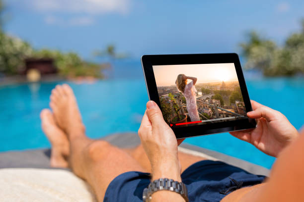 istock Man watching movie on tablet by the pool. 1031313546