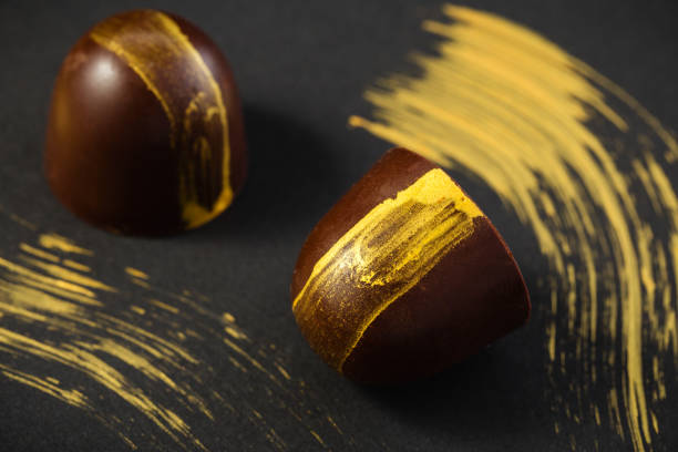 istock Luxury bonbons painted with gold on black background 1031318204