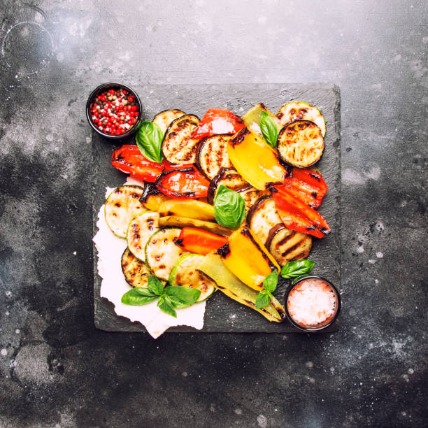 istock Grilled multicolored vegetables, aubergines, zucchini, pepper with green basil on serving stone board 1031320916