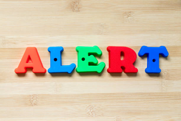 istock Color plastic alphabet in word alert on wood background 1031321046