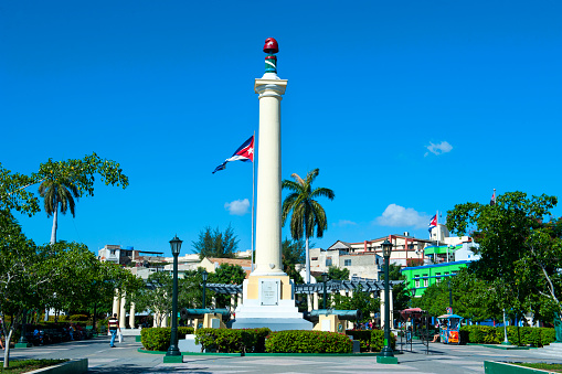 Santiago de Cuba, Cuba, January 06, 2017: Liberty column and cuban flag in Plaza de Marte.