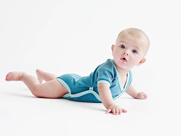 kuvapankkikuvat ja rojaltivapaat kuvat aiheesta baby in blue onesie on white - mahallaan makaava