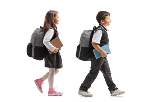 istock Schoolgirl and schoolboy with backpacks walking 1031340828