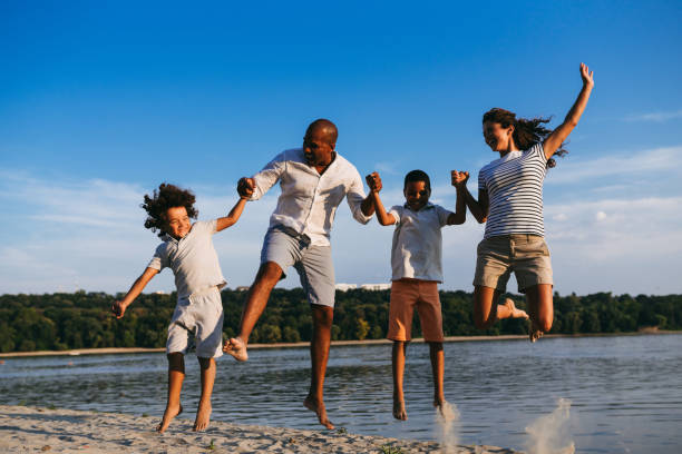 istock Carefree family having fun while jumping on the beach 1031351288