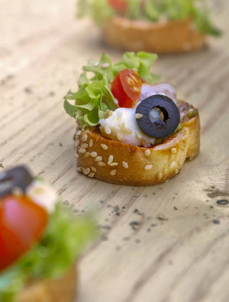 Traditional italian bruschetta with cherry tomatoes, cream cheese, basil leaves, capers and balsamic vinegar on wooden table. stock photo