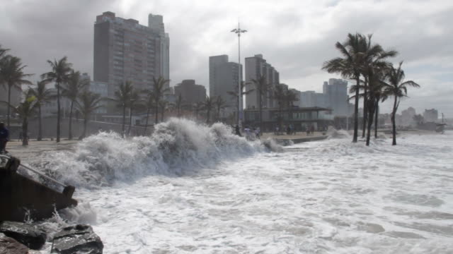 Waves breaching barrier wall at Durban's beachfront.