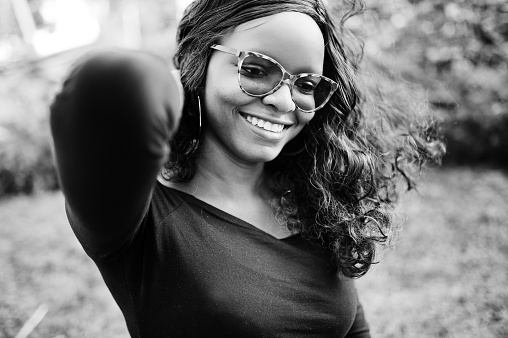 Close up portrait of african american girl in sunglasses, black clothes posed outdoor. Fashionable black woman.