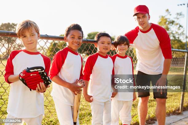 Photo libre de droit de Entraîneur Et Les Jeunes Garçons Dans Une Équipe De Baseball À La Recherche Dappareil Photo banque d'images et plus d'images libres de droit de Baseball