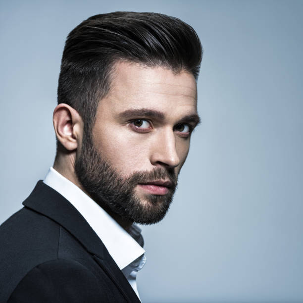 Handsome man in black suit with white shirt Handsome man in black suit with white shirt - posing at studio. Attractive guy with fashion hairstyle. Confident man with short beard. Adult boy with brown hair. men hair cut stock pictures, royalty-free photos & images