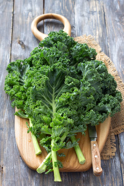 istock Fresh green curly kale leaves on a cutting board on a wooden table 1031368700