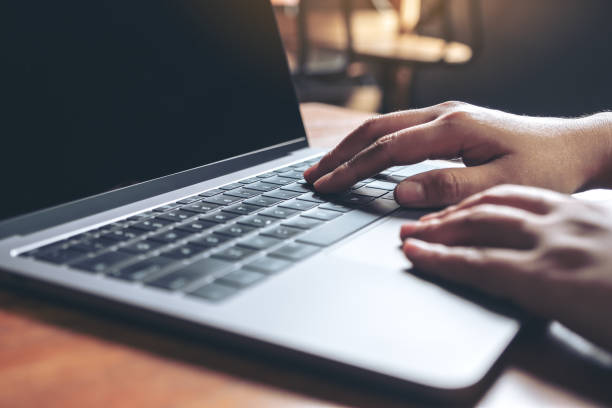 istock Closeup image of hands using and typing on laptop keyboard on wooden table 1031368926