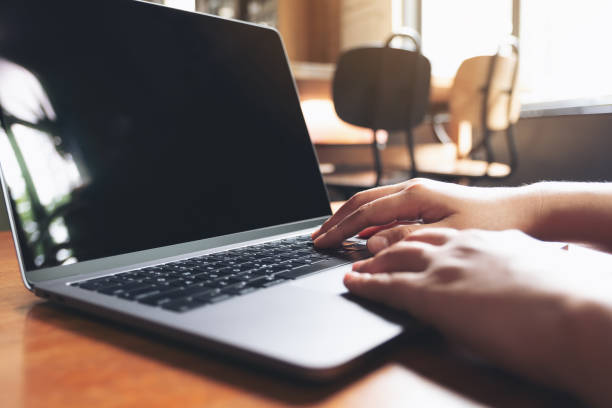istock Closeup image of hands using and typing on laptop keyboard on wooden table 1031368946
