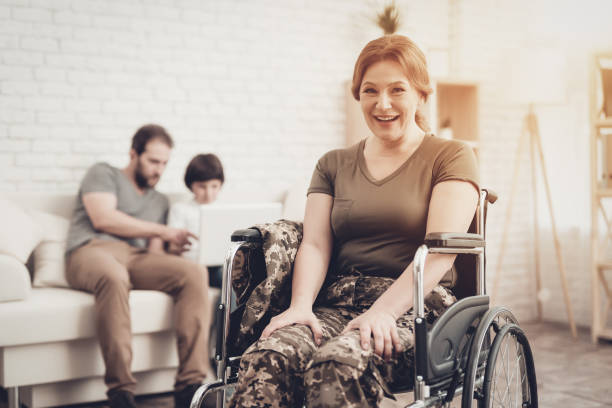 Smiling Woman. Disabled Soldier In A Wheelchair. Smiling Woman. Disabled Soldier In A Wheelchair. Meeting After War. Son And Husband Background. Camouflage Uniform. Family Background. Paralyzed Soldier. Home Leisure. Return From Army. paraplegic stock pictures, royalty-free photos & images