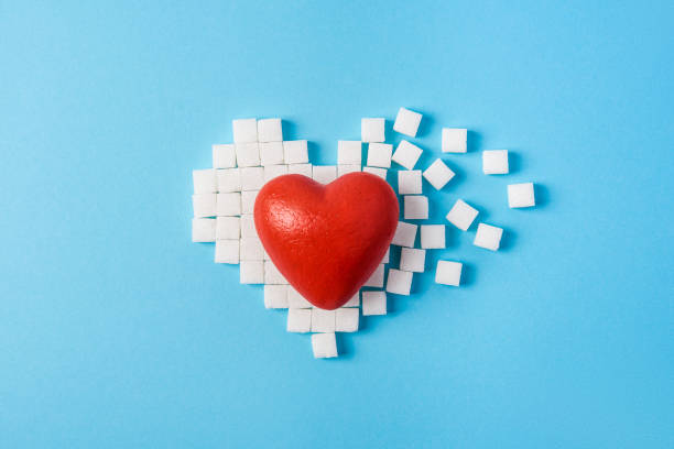big red heart on broken heart made of sugar cubes on a blue back stock photo