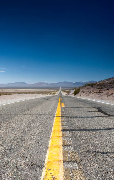 istock Long Distant Highway Under the Summer Sun Across Death Valley National Park. 1031372602