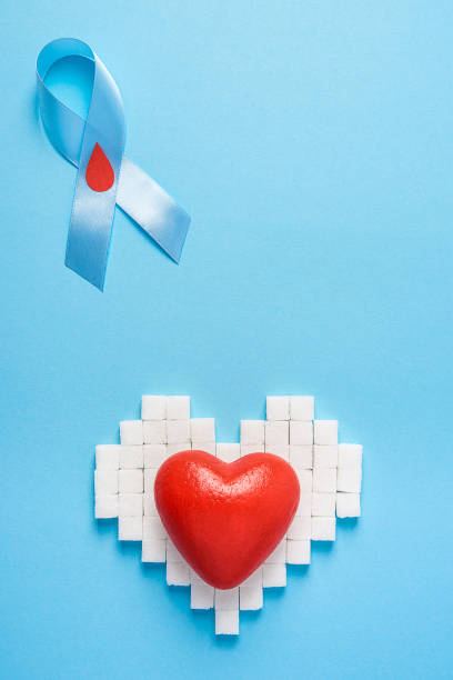 blue ribbon awareness with red blood drop and red heart on a hea stock photo