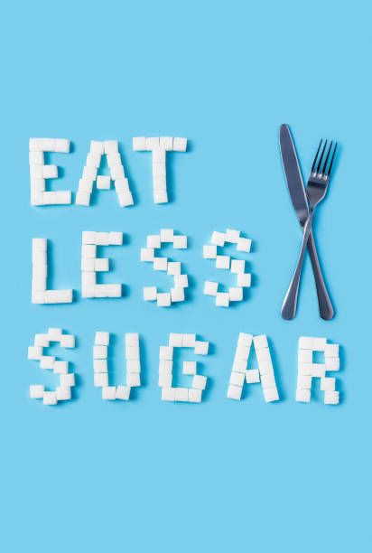 eat less sugar inscription made of sugar cubes isolated on trendy blue background stock photo