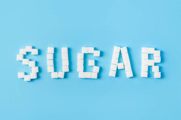 sugar inscription made of sugar cubes isolated on trendy blue background stock photo