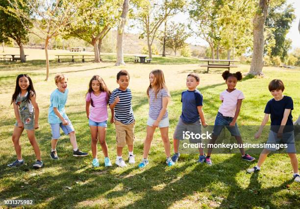 Foto de Grupo Multiétnico De Crianças Brincando No Parque e mais fotos de stock de Criança - Criança, Dançar, Exterior